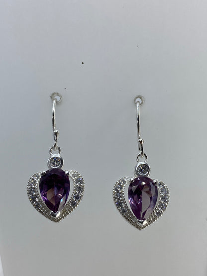 Vista frontal de los dos aretes mostrando el engaste detallado de las piedras en corazón
