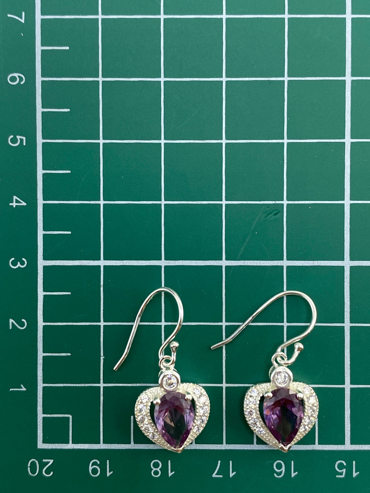 Aretes sobre estuche azul con la báscula mostrando el peso de 3.74 gramos