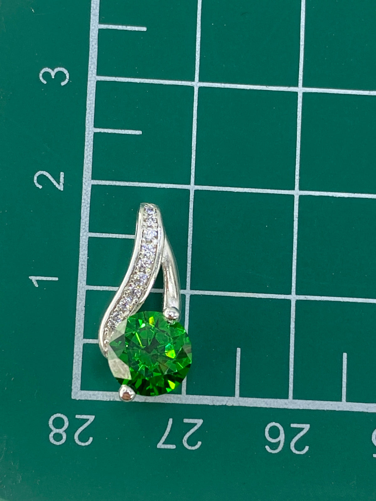 Pesaje del dije en balanza, mostrando 2.4 gramos de plata auténtica