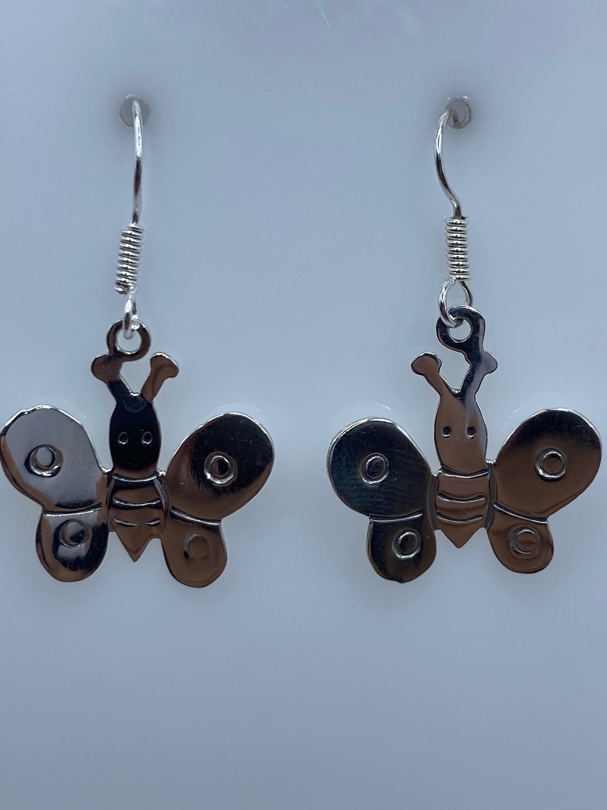 Aretes de plata mariposa en escala de medidas, mostrando su tamaño de 3.2 cm