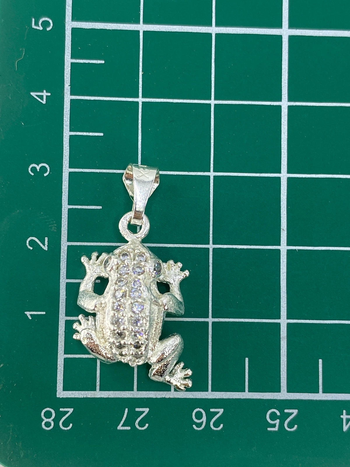 Dije rana de 3 cm sobre escala, mostrando el tamaño real de la pieza
