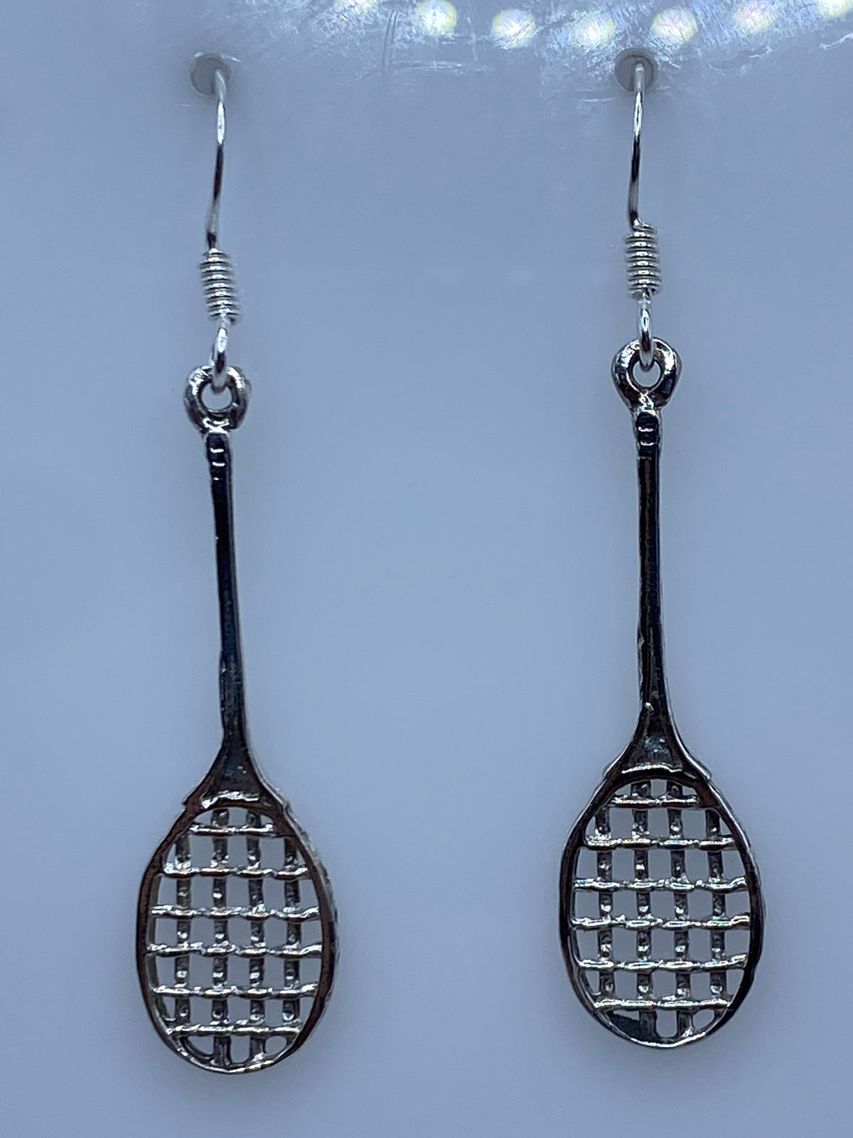 Aretes sobre regla de medición mostrando largo de 4.9 cm