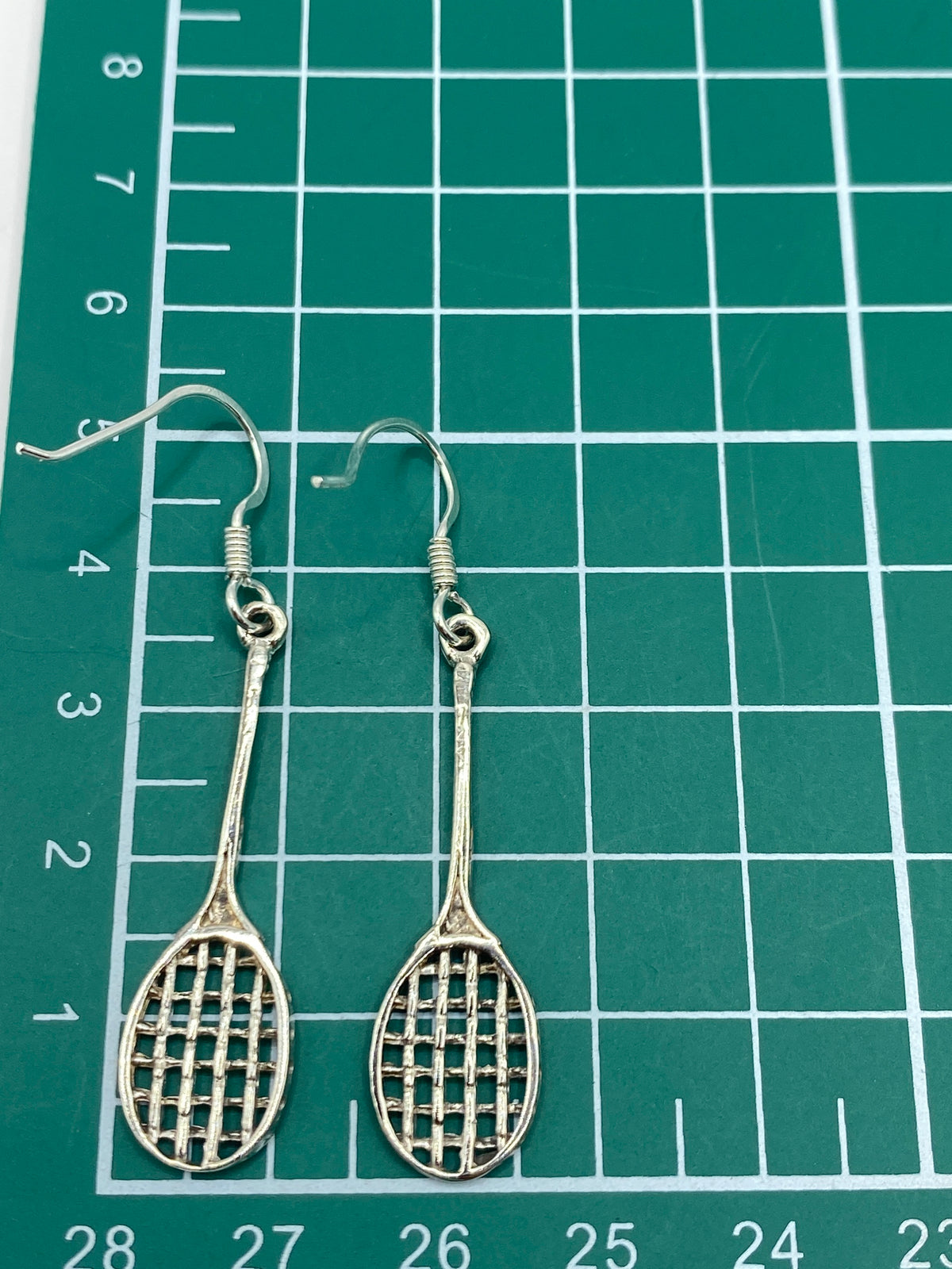 Aretes de plata calado raquetas con ganchos de pescador en primer plano