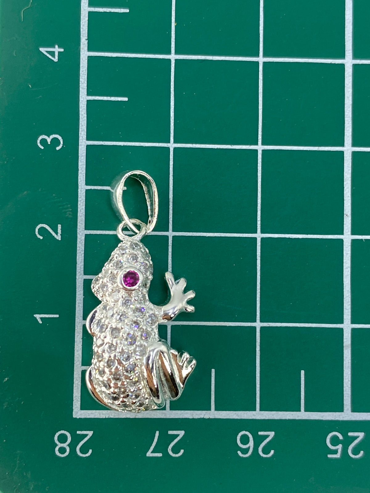 Dije de sapo de 2.6 cm sobre regla métrica, vista de escala