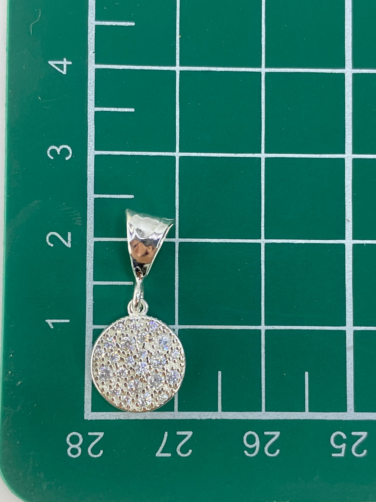 Dije de plata 925 con Quinto visible, fotografiado sobre fondo gris