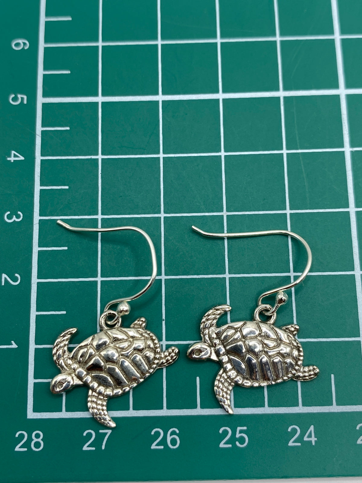Ambos aretes de tortuga marina lado a lado en estuche de Arte Taxco