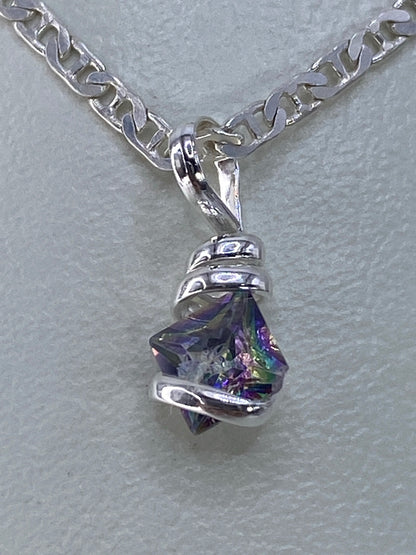 Circonia multicolor engastada en plata mostrando destellos de azul, púrpura y amarillo