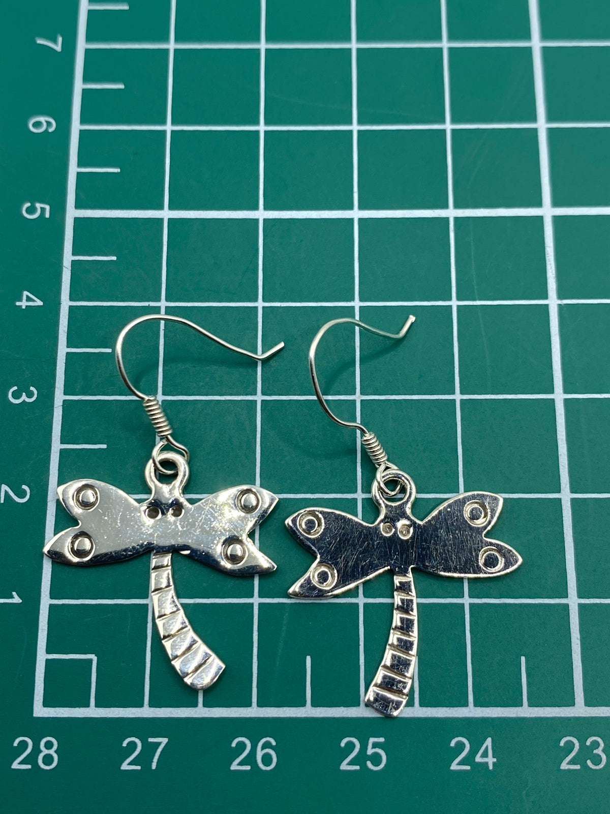 Aretes en la mano, escala real de 3.5 cm de largo cada uno