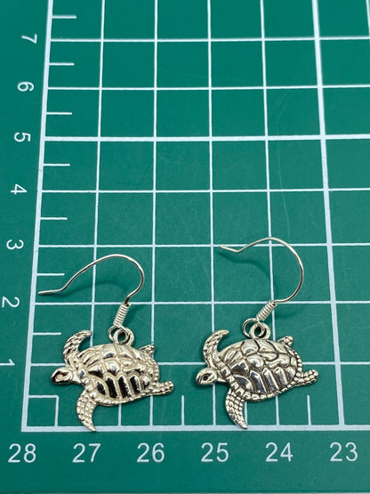 Aretes de tortuga marina colgando de gancho de plata, vista lateral