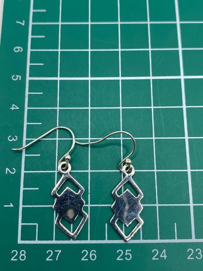 Aretes sobre fondo blanco mostrando el sello 925 del Quinto