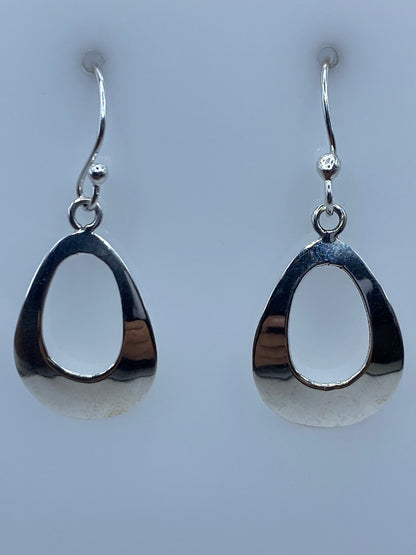 Aretes de plata calado en forma de gota, diseño minimalista sobre fondo gris