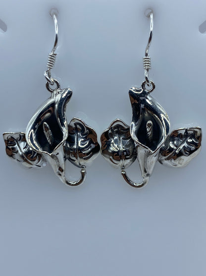 Detalle lateral de arete floral mostrando los pétalos en capas y el acabado artesanal