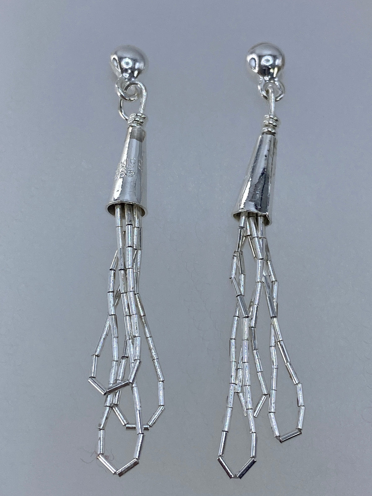 Aretes medidos en regla mostrando largo de 5 cm del par