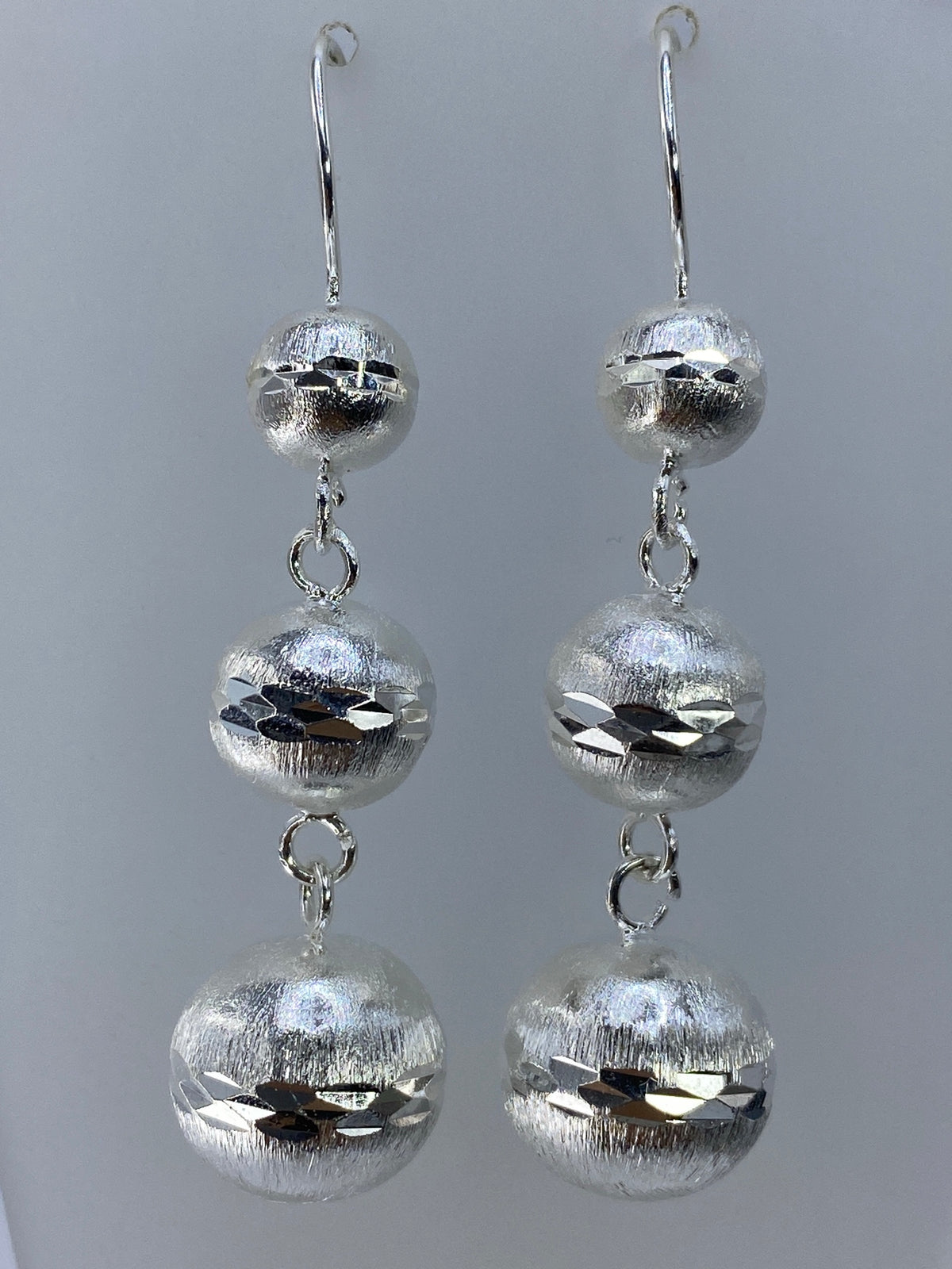 Detalle de los cortes geométricos contrastantes en cada esfera de plata