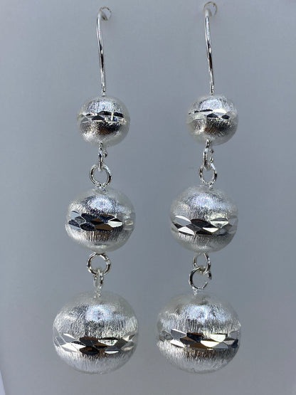 Detalle de los cortes geométricos contrastantes en cada esfera de plata