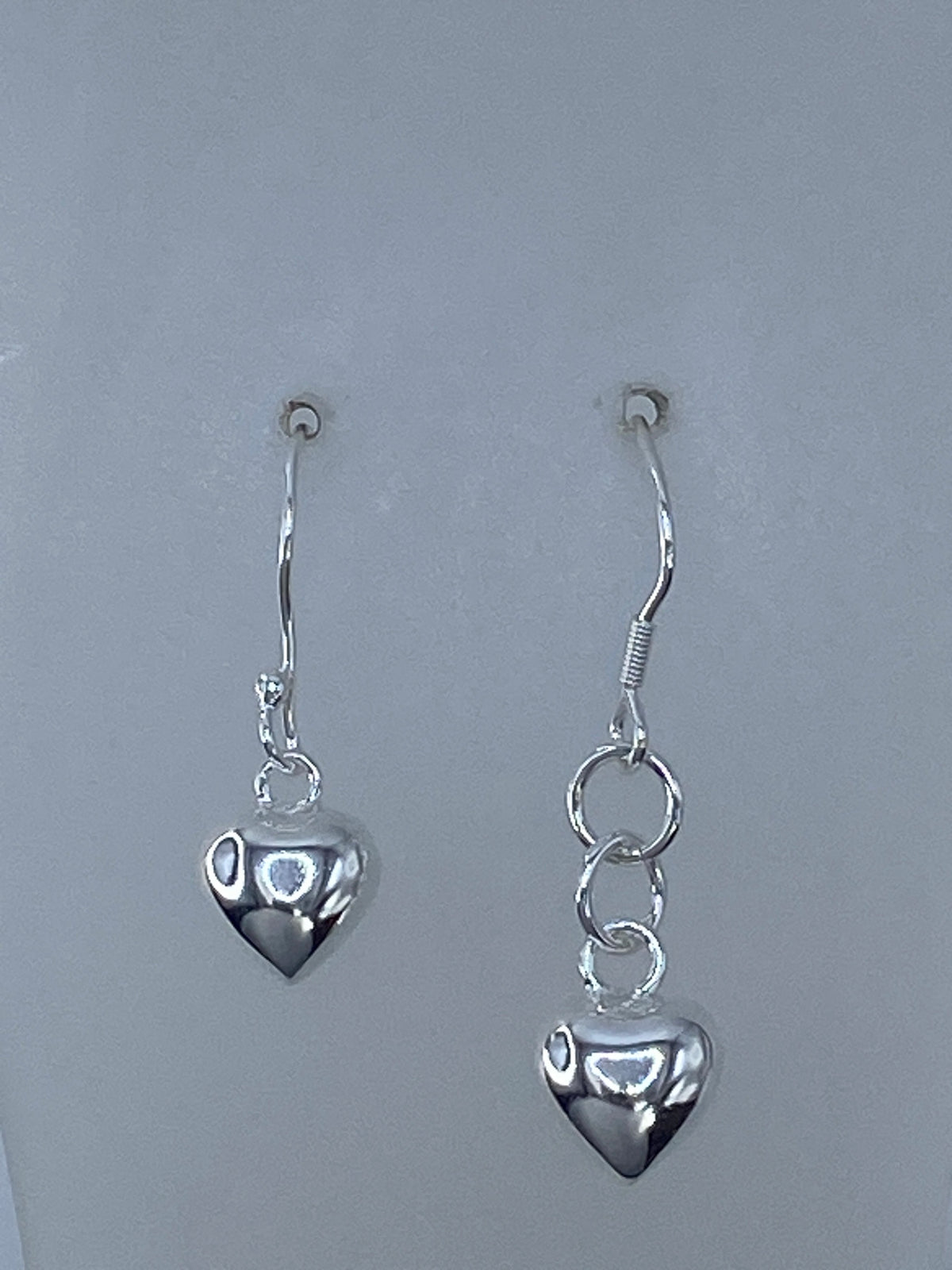 Vista frontal del arete de plata con corazón minimalista y gancho de plata 925