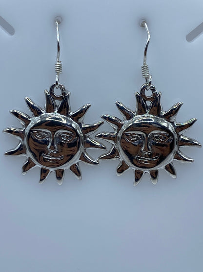 Detalle de un arete sol mostrando el rostro grabado y el acabado pulido de la plata
