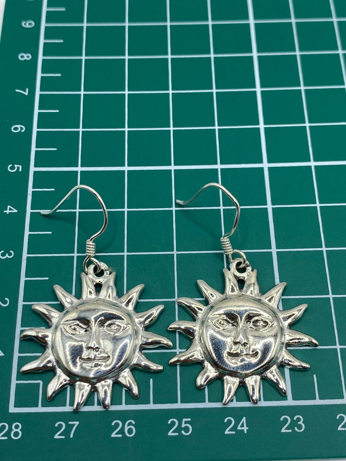 Aretes sol de plata 925 con Quinto visible, sobre fondo claro