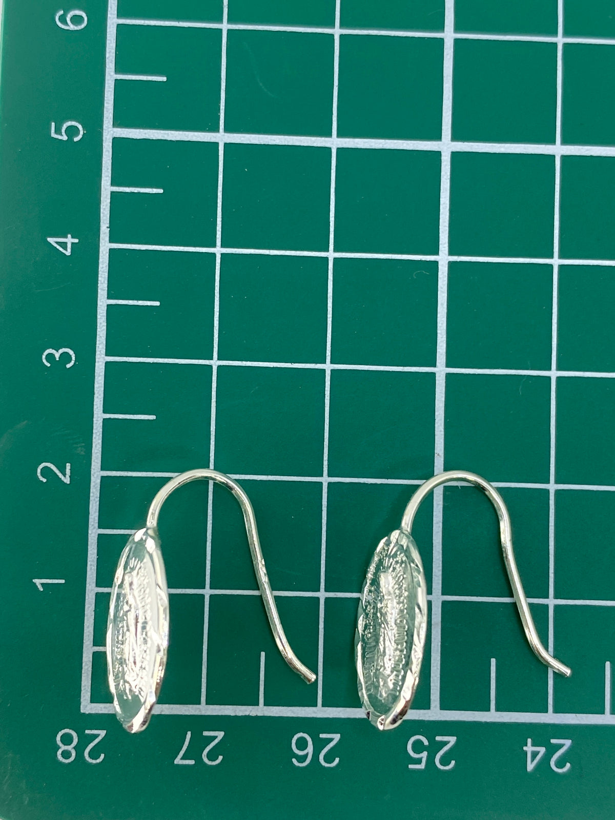 Aretes en la mano mostrando el peso ligero y el acabado pulido