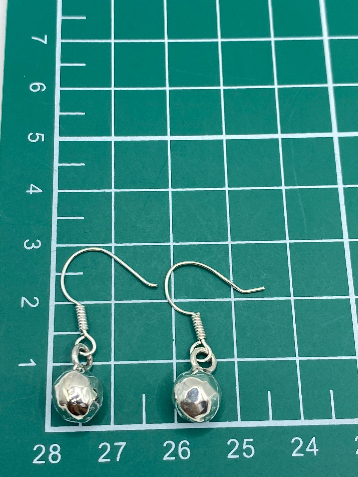 Aretes sobre fondo blanco con el Quinto 925 visible