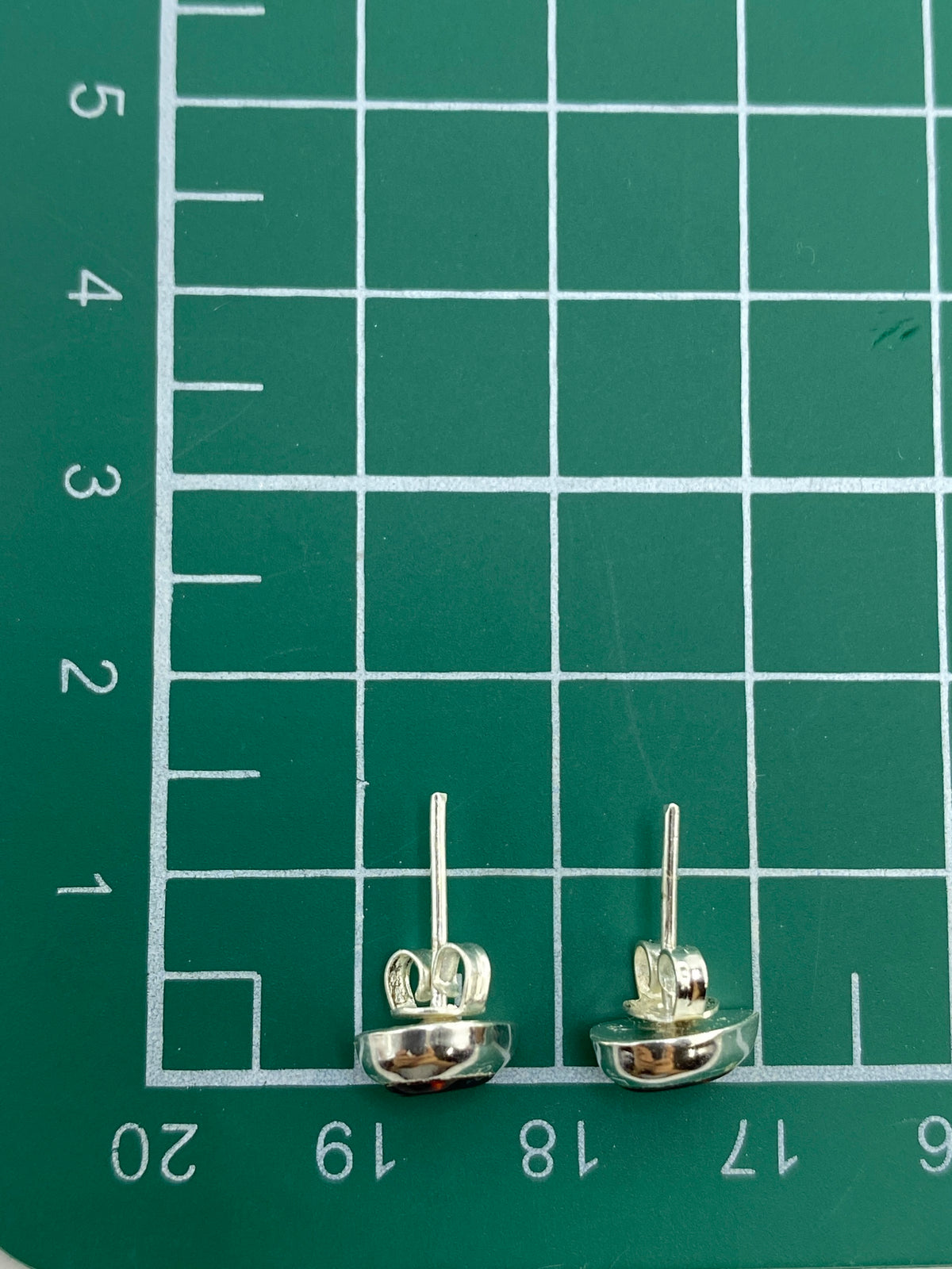 Aretes de plata con ópalo multicolor mostrando el Quinto 925 en la base