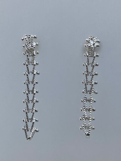 Par de aretes largos minimalistas de plata 925 sobre fondo gris