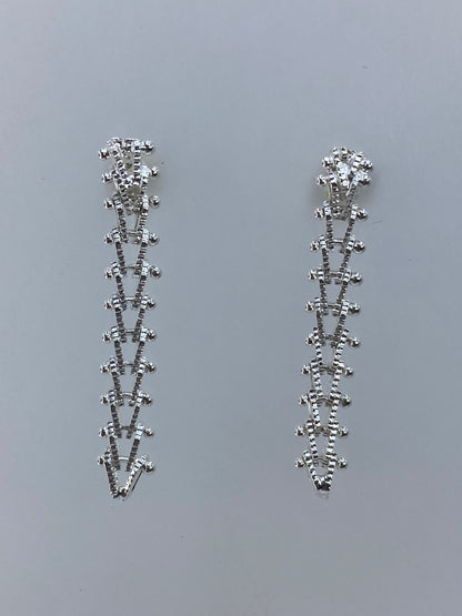 Detalle de los aretes Taxco mostrando el pulido brillante y la línea recta