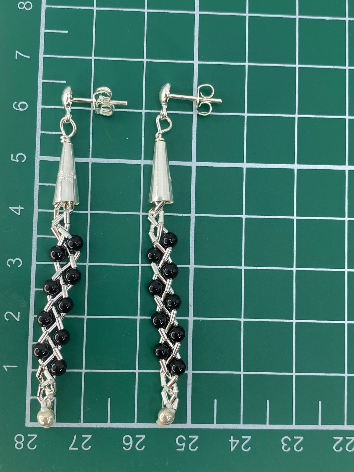 Aretes sobre balanza mostrando peso de 3.4 g por el par