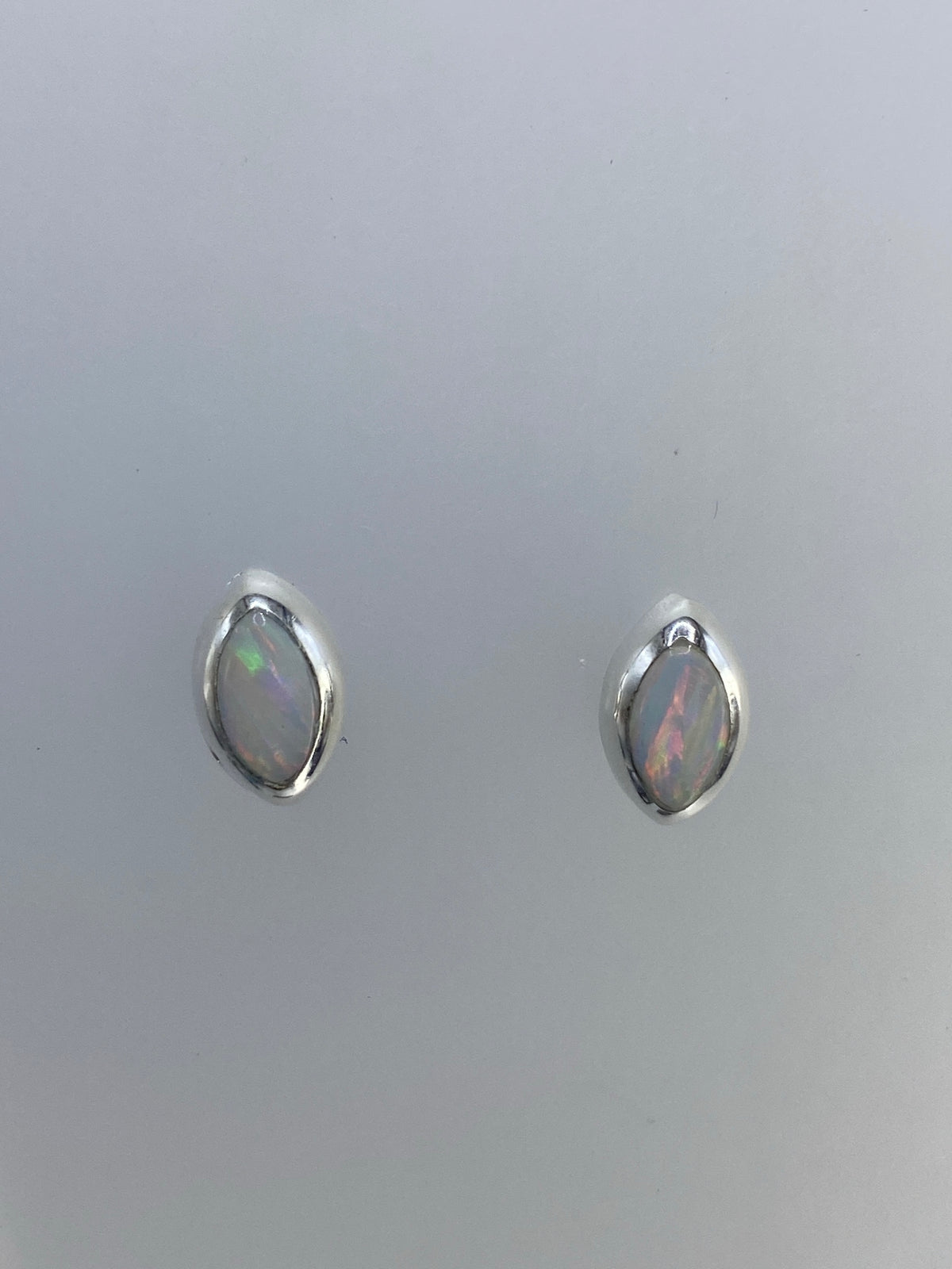 Aretes de ópalo de fuego vistos de frente, engastados en plata 925