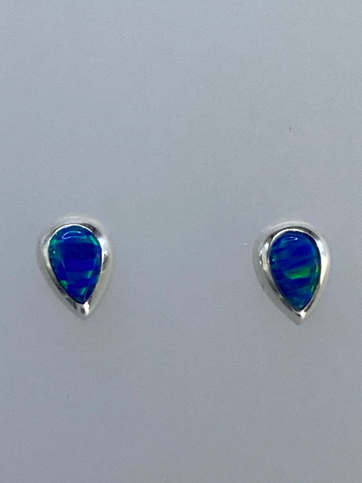 Aretes de botón en plata 925 con ópalo de fuego multicolor — vista frontal mostrando el juego de colores