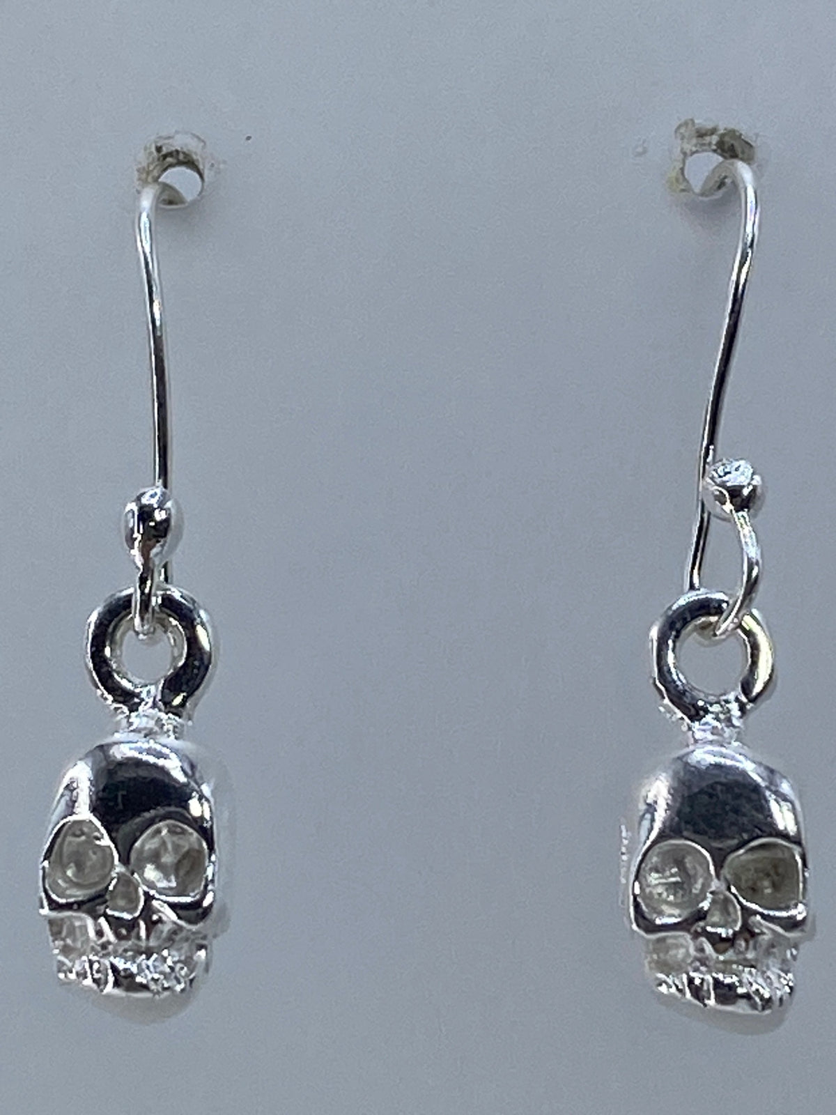 Aretes sobre regla de centímetros mostrando medida real de 2.5 cm
