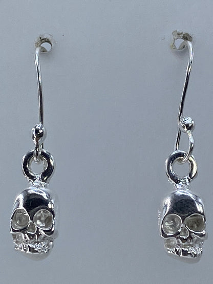 Aretes sobre regla de centímetros mostrando medida real de 2.5 cm