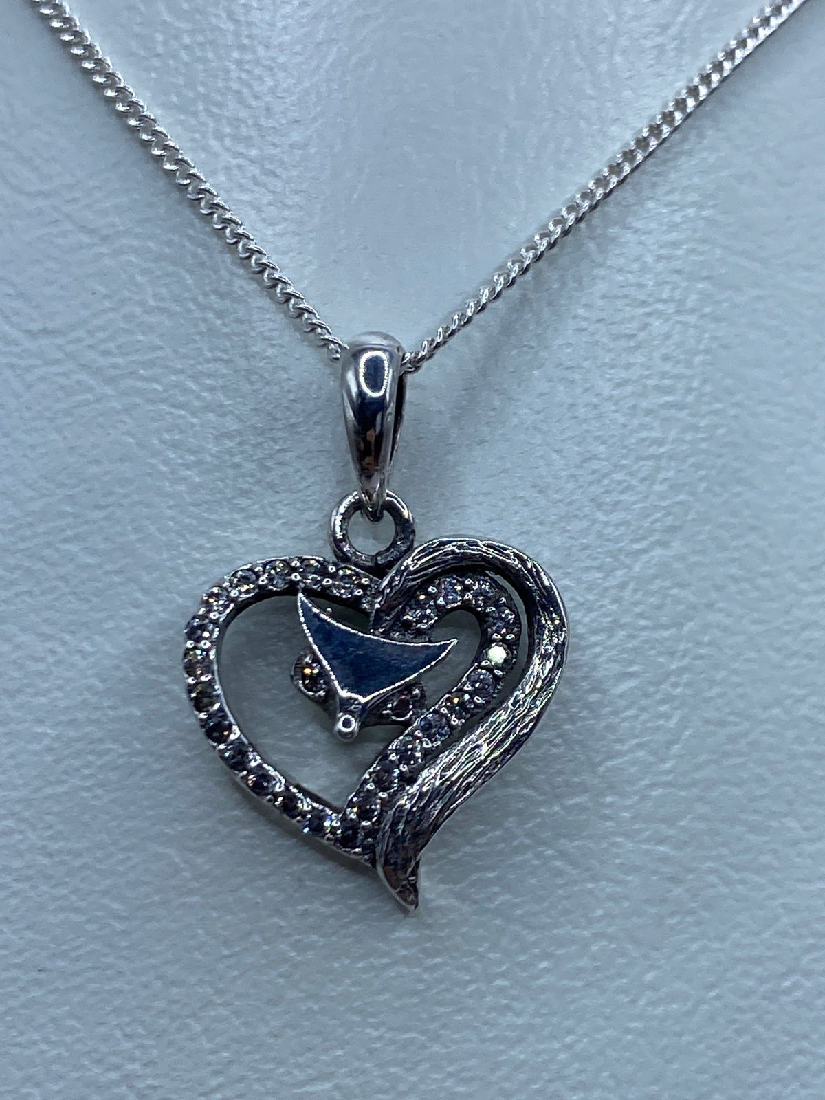 Dije corazón de plata sobre regla métrica mostrando 2.1 cm de largo