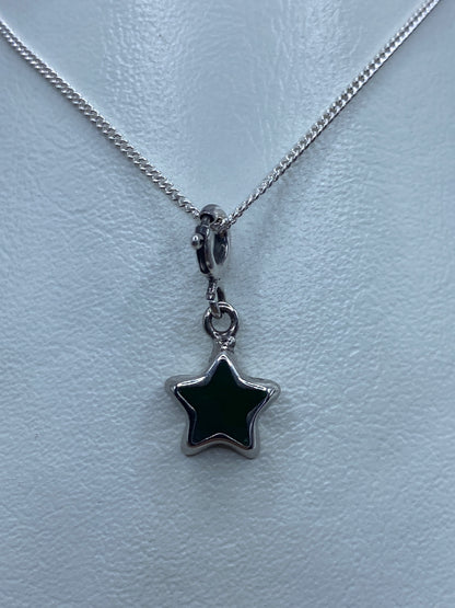 Dije de estrella de plata 925 con piedra verde engastada, colgando de una cadena