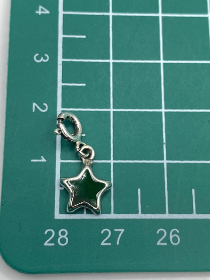 Dije de estrella sobre fondo blanco con escala de medida, mostrando tamaño de 2 × 1 cm