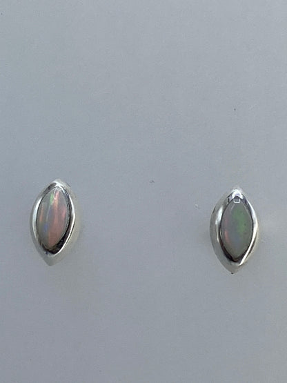 Aretes de ópalo de fuego sobre fondo blanco, con luz que destaca los destellos