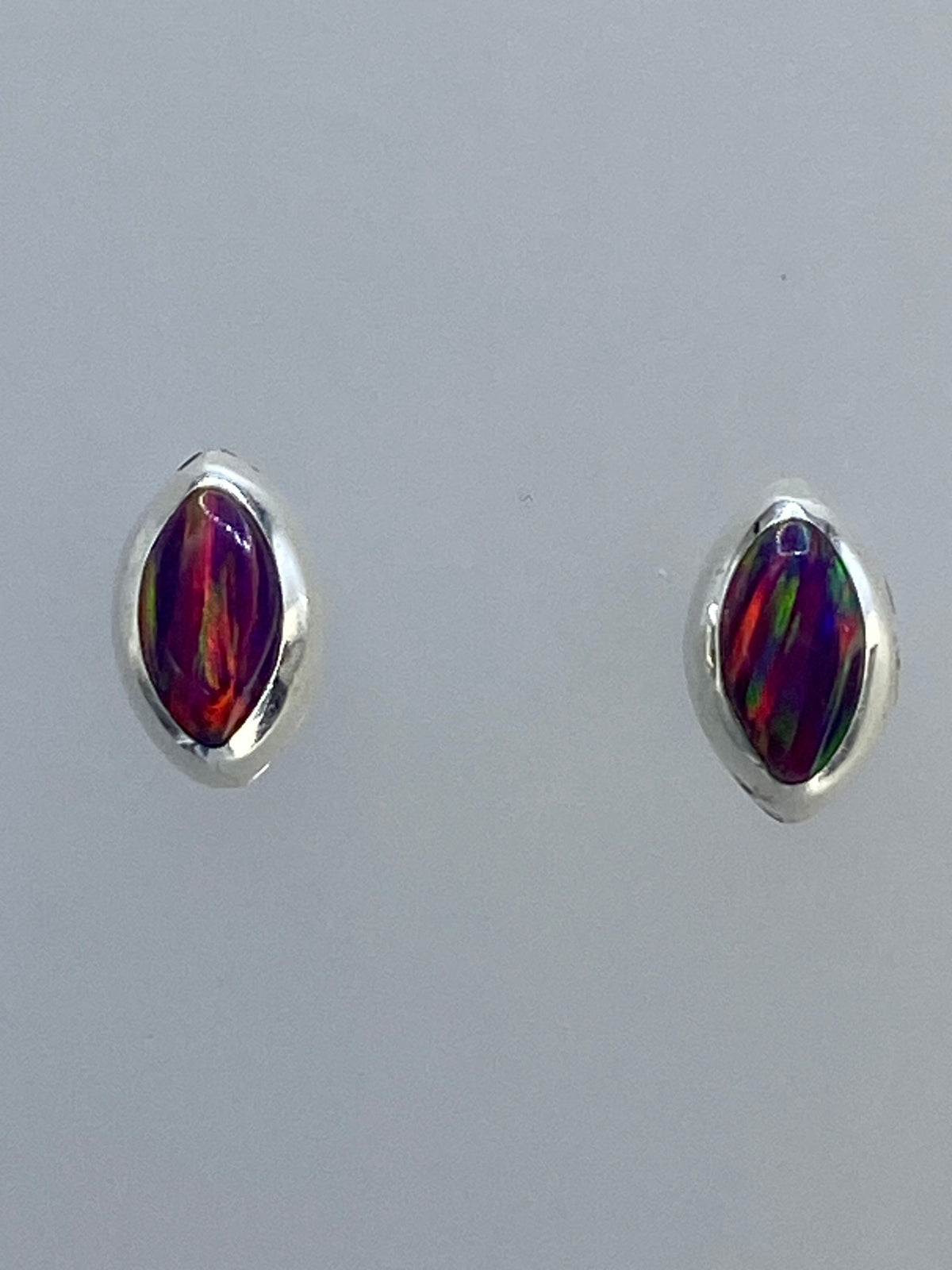 Par de aretes de plata con ópalo de fuego multicolor, detalles de la piedra con tonos rojo, naranja y verde