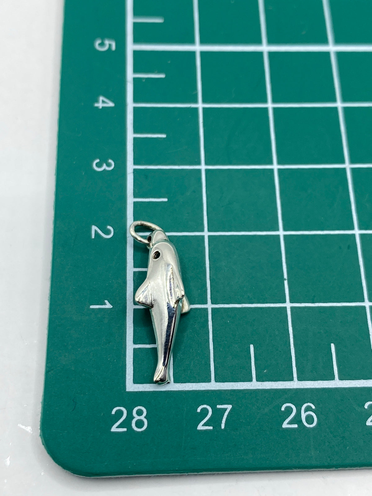 Delfín de plata sobre escala de peso, 0.92 gramos
