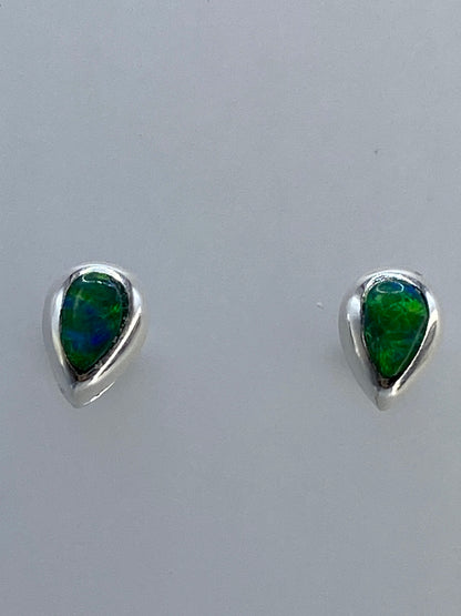 Aretes sobre regla de centímetros mostrando tamaño compacto de la gota