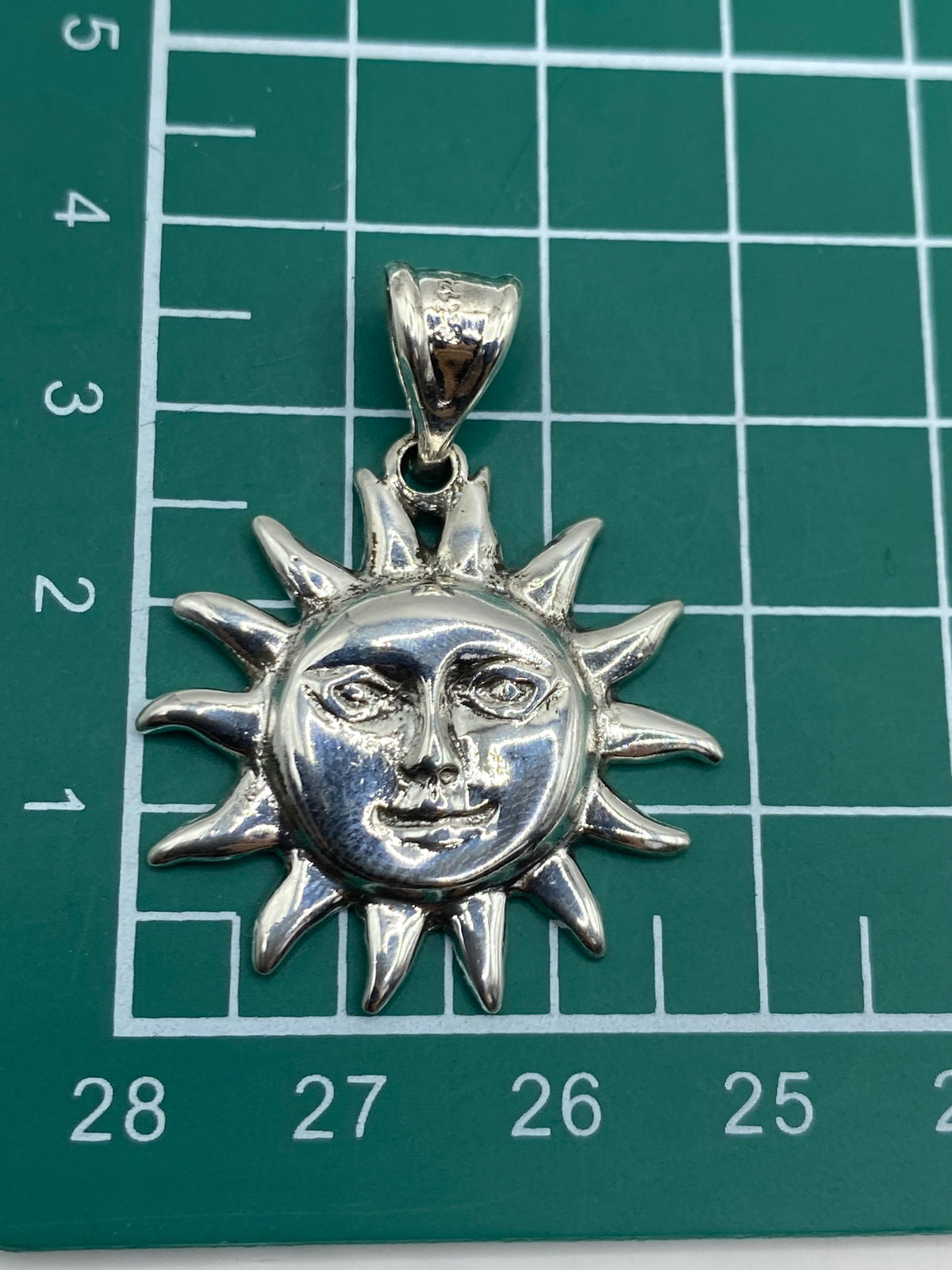 Reverso del dije de sol con marca de Quinto 925 y acabado de fundición