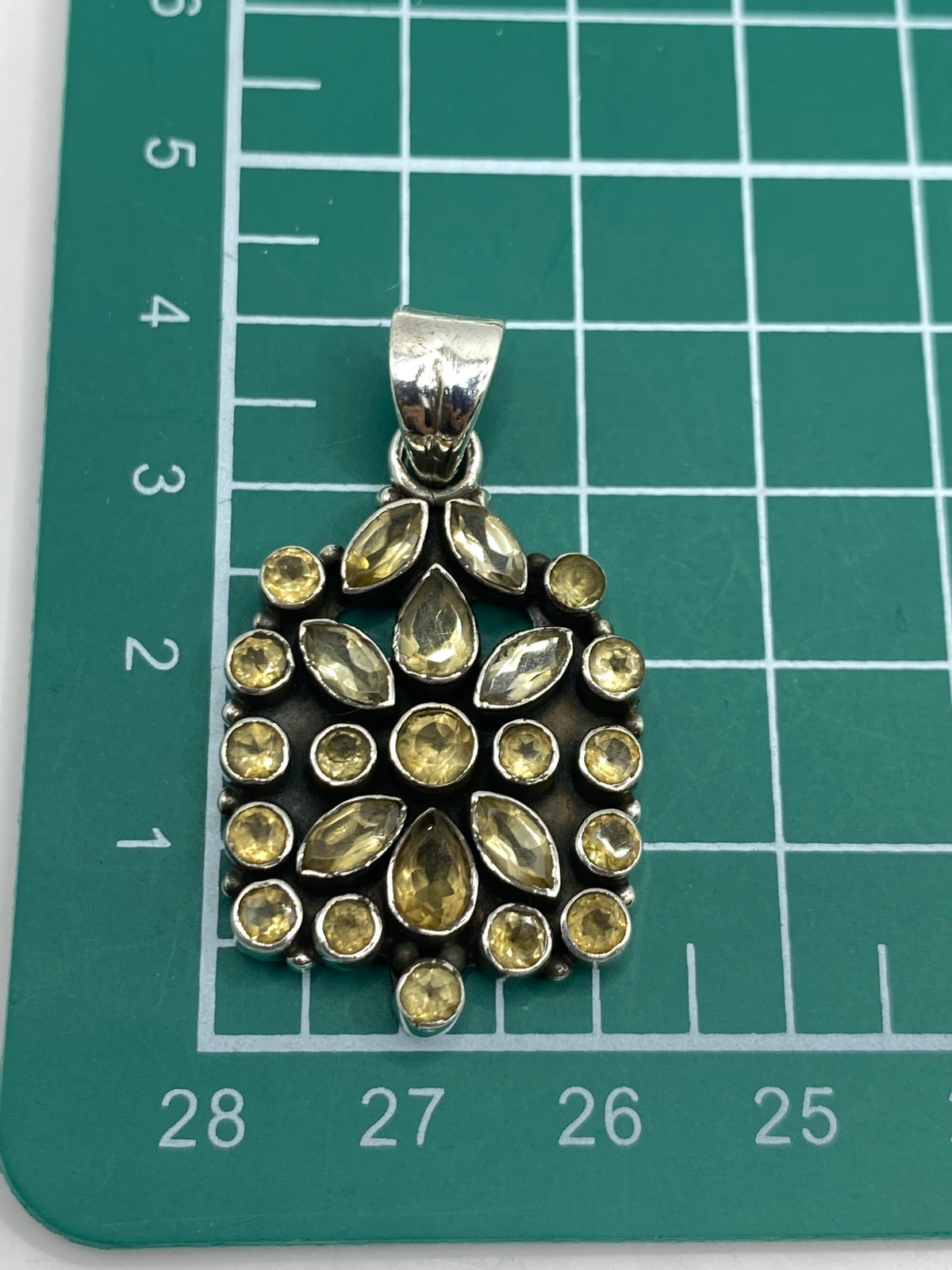 Dije sobre escala de medidas indicando 4 × 2.2 cm