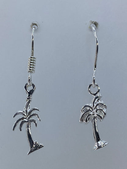 Par de aretes de plata 925 con palmera repujada, 3 cm de largo, colgando sobre fondo blanco