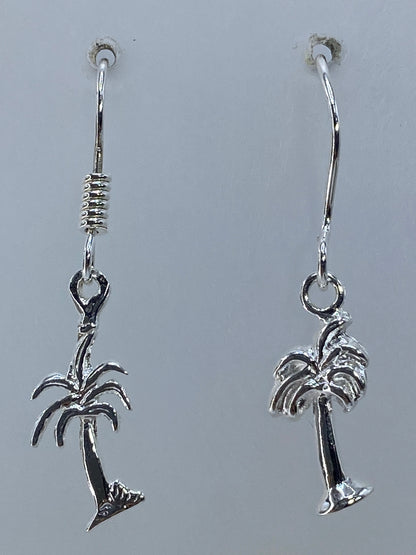 Aretes de plata palmera en la oreja, luciendo ligeros y minimalistas