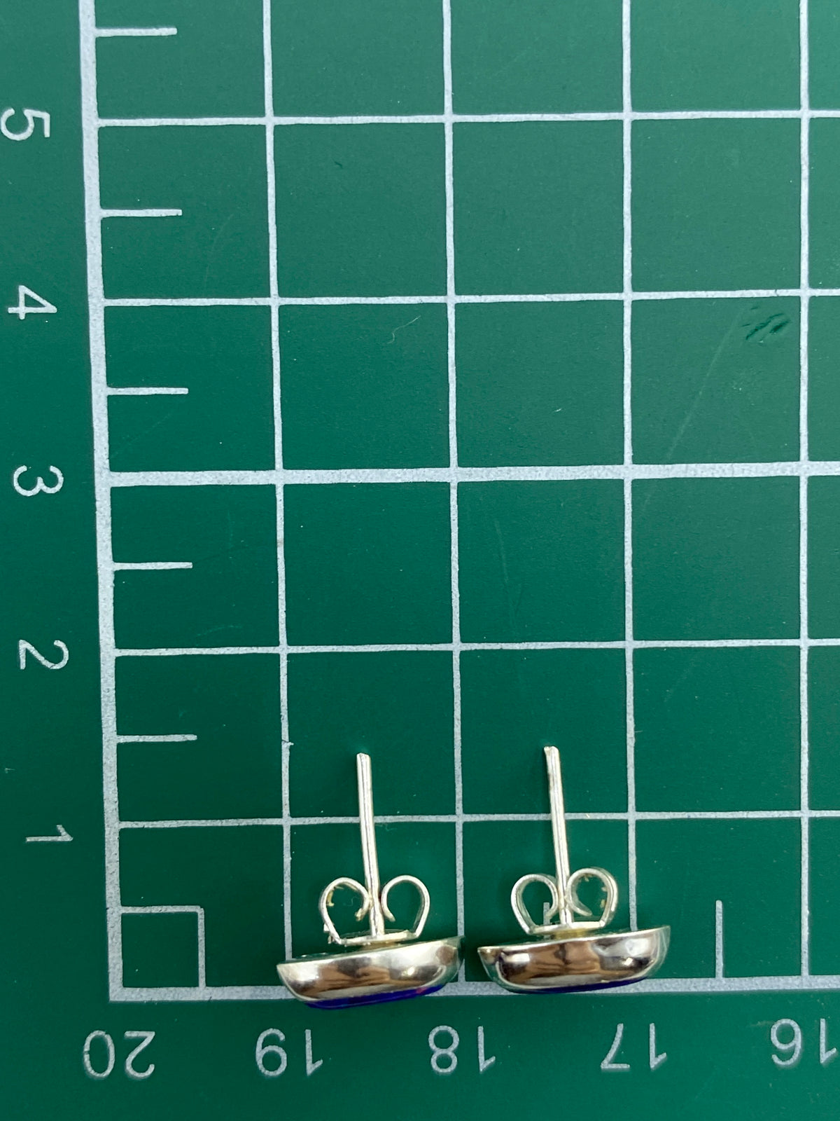 Aretes sobre fondo blanco, mostrando el Quinto 925 y el brillo del ópalo
