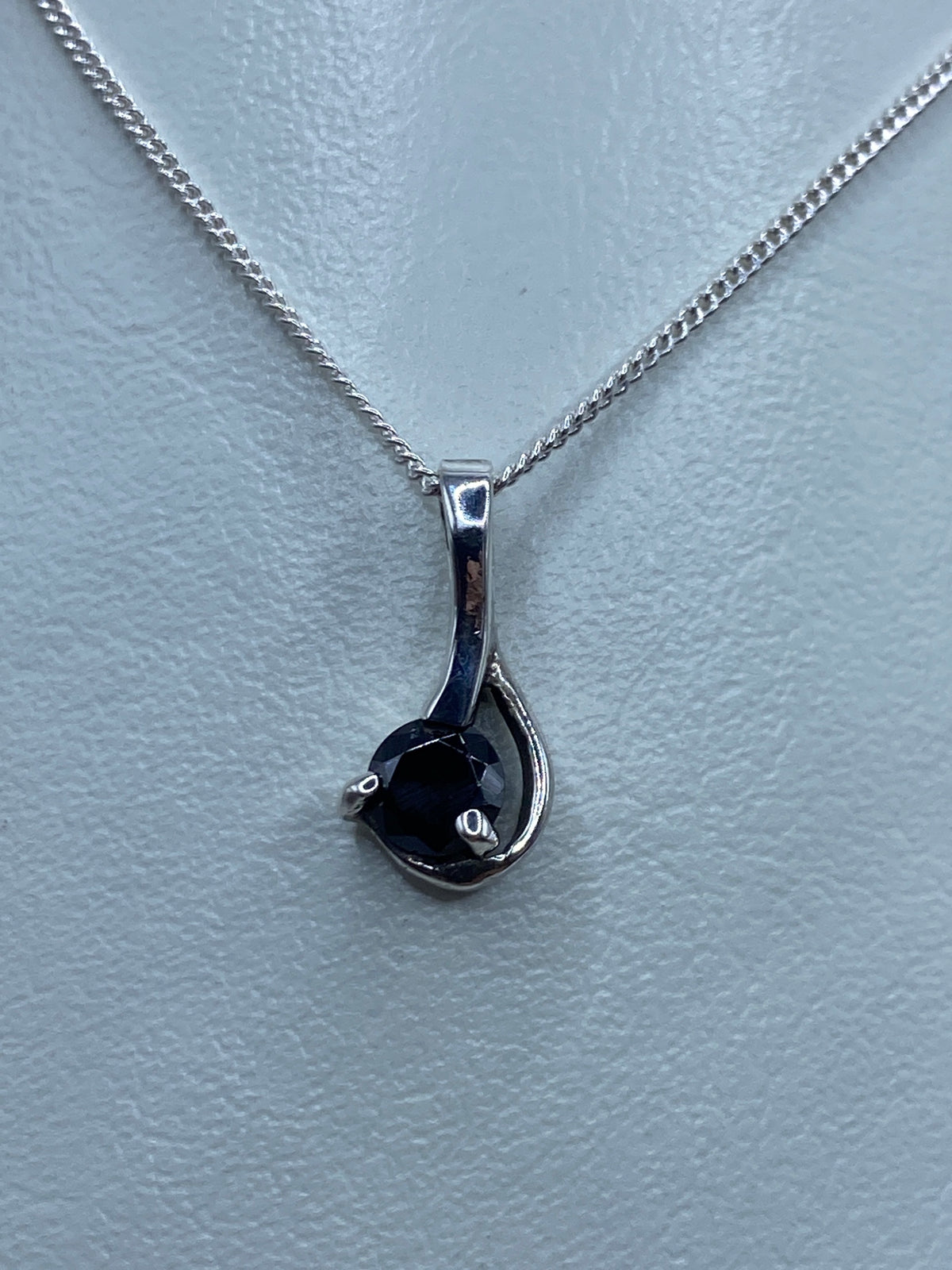 Dije de plata 925 con circonia negra engastada, colgando de cadena plateada