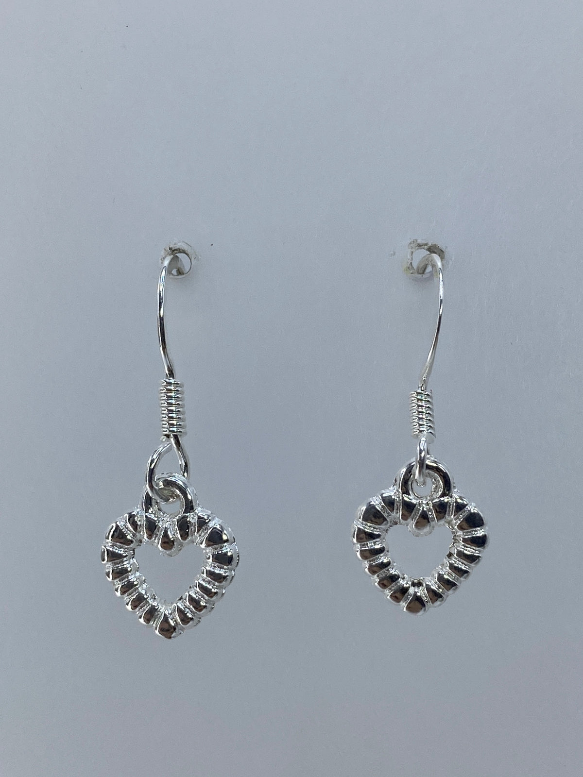 Detalle cercano del repujado: texturas y relieves de luz en los corazones de plata