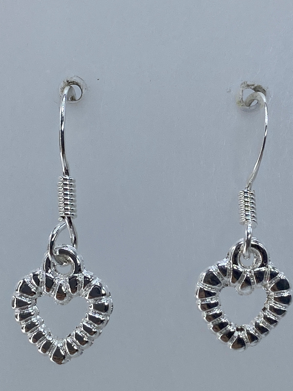 Aretes sobre regla de medición mostrando 2.1 cm de largo