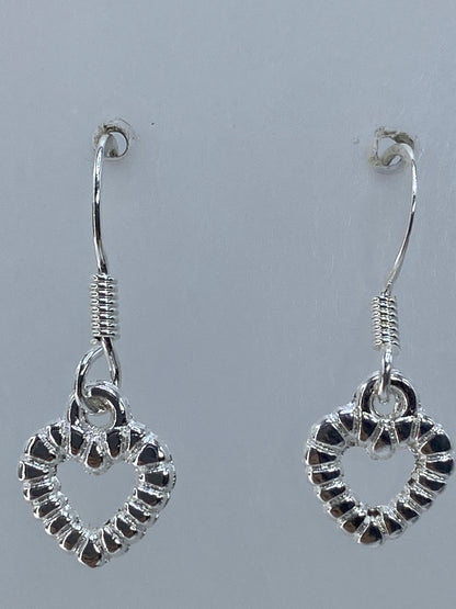 Aretes sobre regla de medición mostrando 2.1 cm de largo