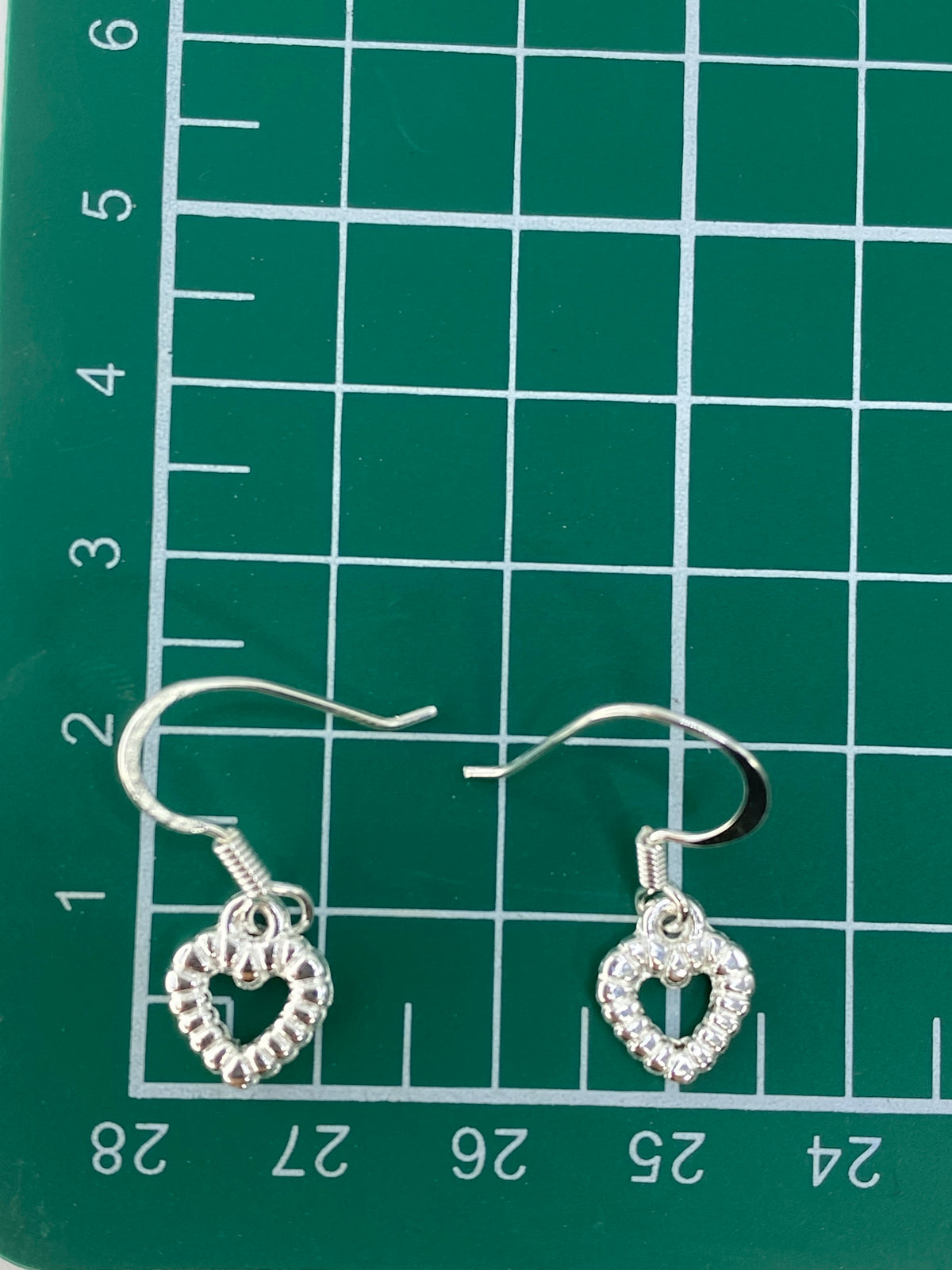 Aretes en balanza de precisión mostrando 1.8 gramos totales