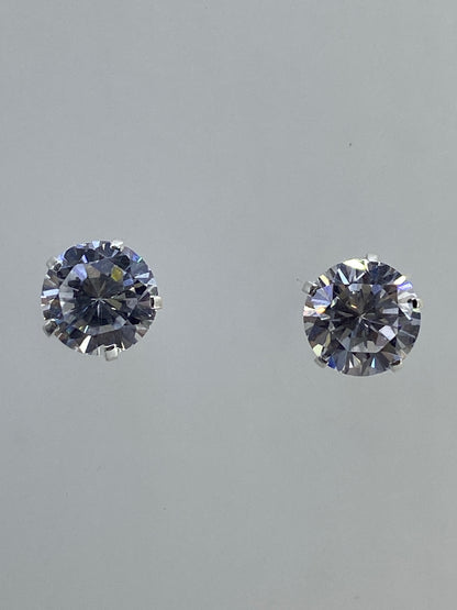Aretes con poste de presión de plata 925 junto a escala de medida